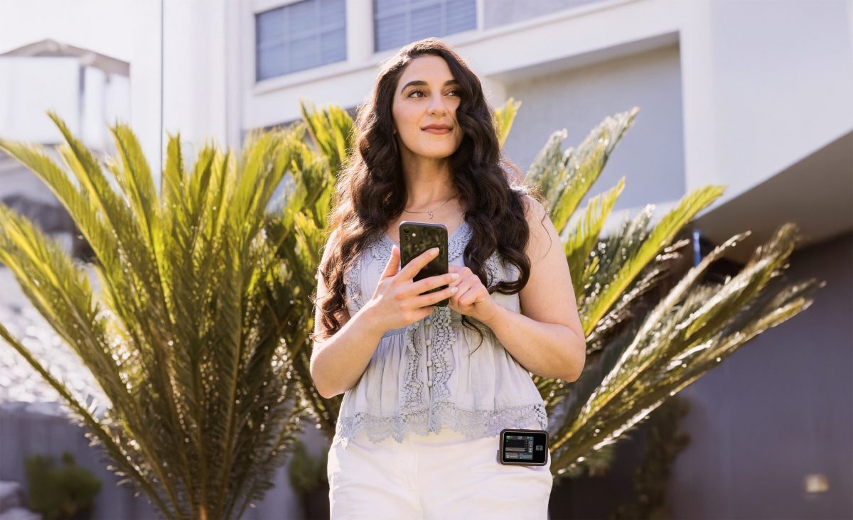Lady wearing the Tandem t:slim insulin pump bolusing from her mobile app